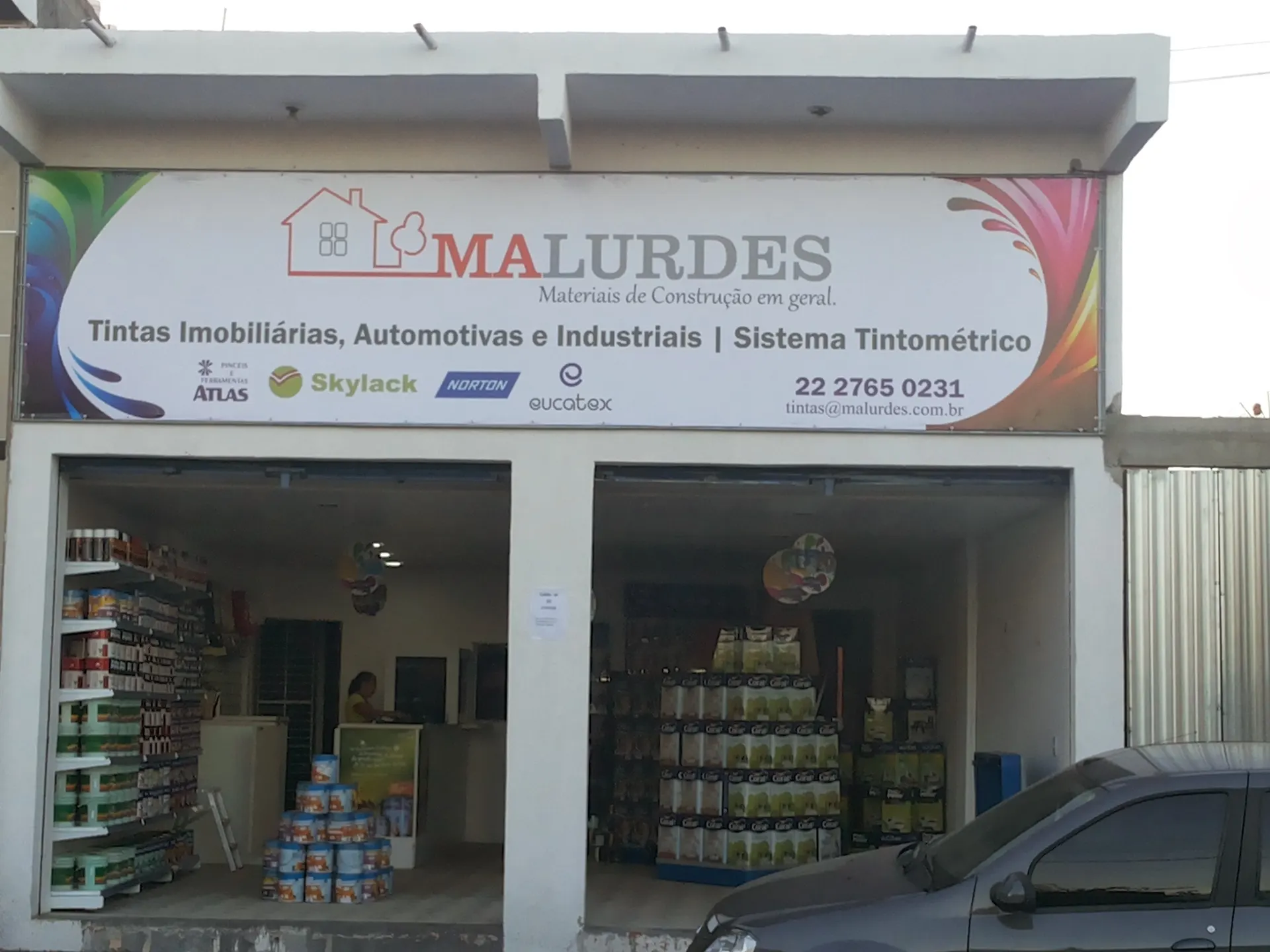 Fachada da loja de tintas da Malurdes com placa de tintas imobiliárias, automotivas e industriais